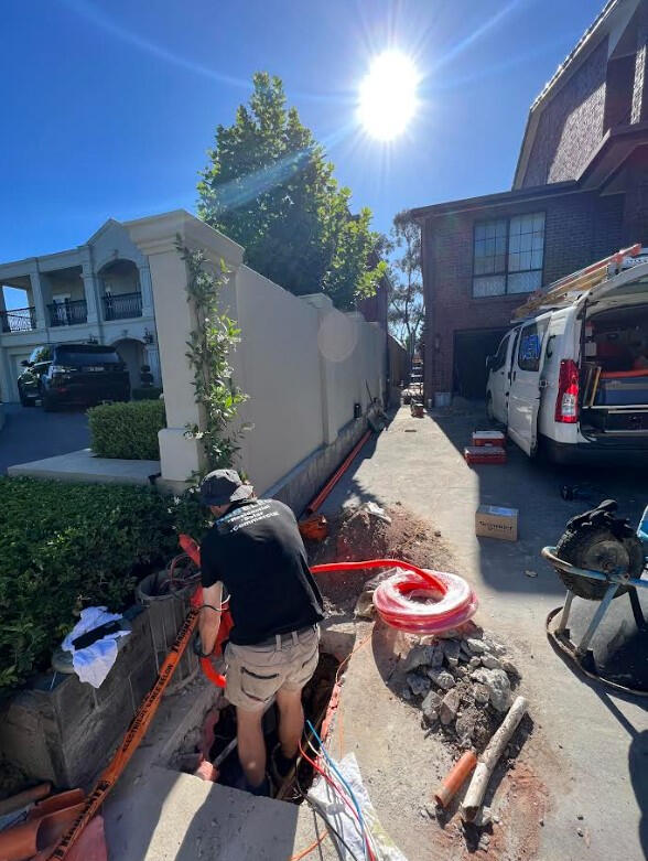 Electrician installing electrical wires for consumer mains, consumer main, and house mains in a residential home.